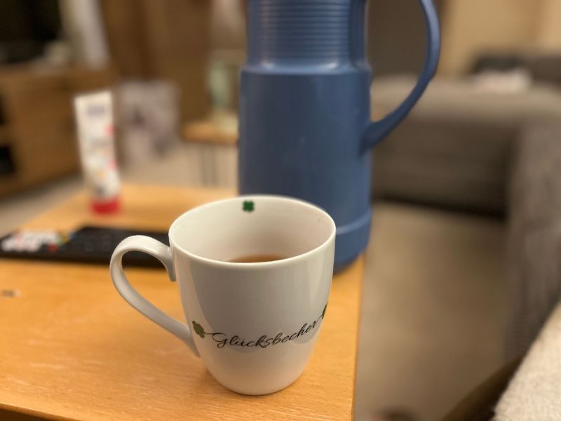 Tasse mit Tee und Thermoskanne