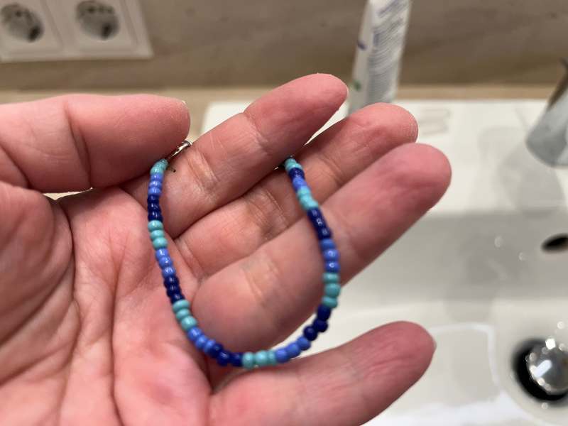 12 von 12 Dezember 2024 - 2 von 12: Hand hält blaues Perlenarmbamd
