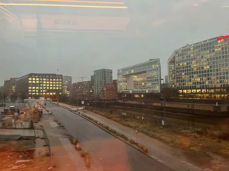 12 von 12 Dezember 2024 - 7 von 12: eine Strasse und beleuchtete Bürogebäude in Hamburg - fotografiert aus dem fahrenden Zug