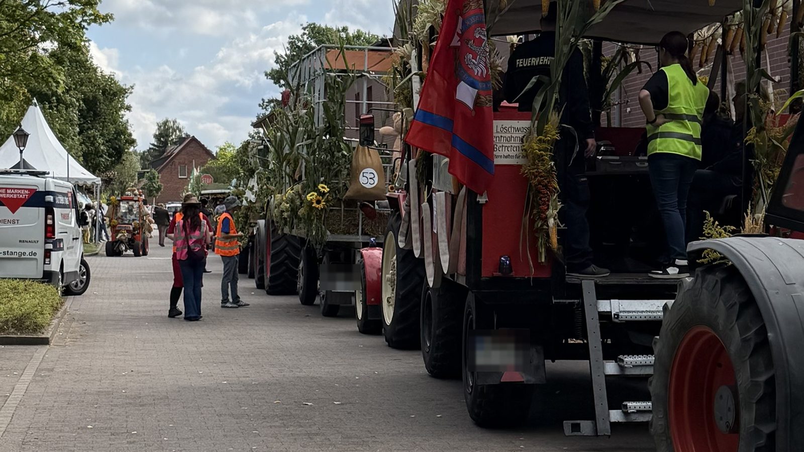 12 von 12 September 2026 - Reihe geschmückter Traktoren und Anhänger, die sich in der Dorfstraße für den Umzug aufstellen