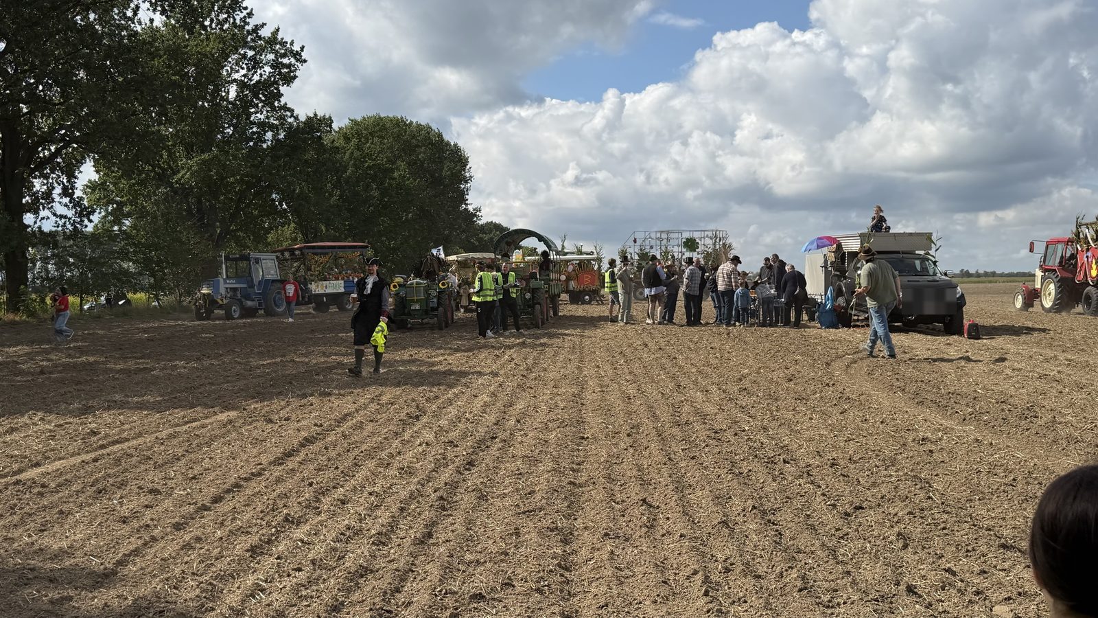 12 von 12 September 2026 - geschmückte Traktoren und Wagen sammeln sich auf einem abgeernteten Acker, Menschen stehen in Gruppen beisammen