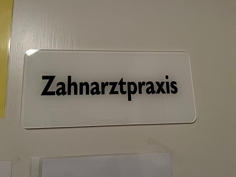 Weißes Türschild mit der Aufschrift "Zahnarztpraxis"