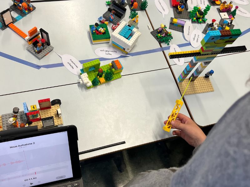 Kind erklärt Modell mit iPad zur Aufnahme