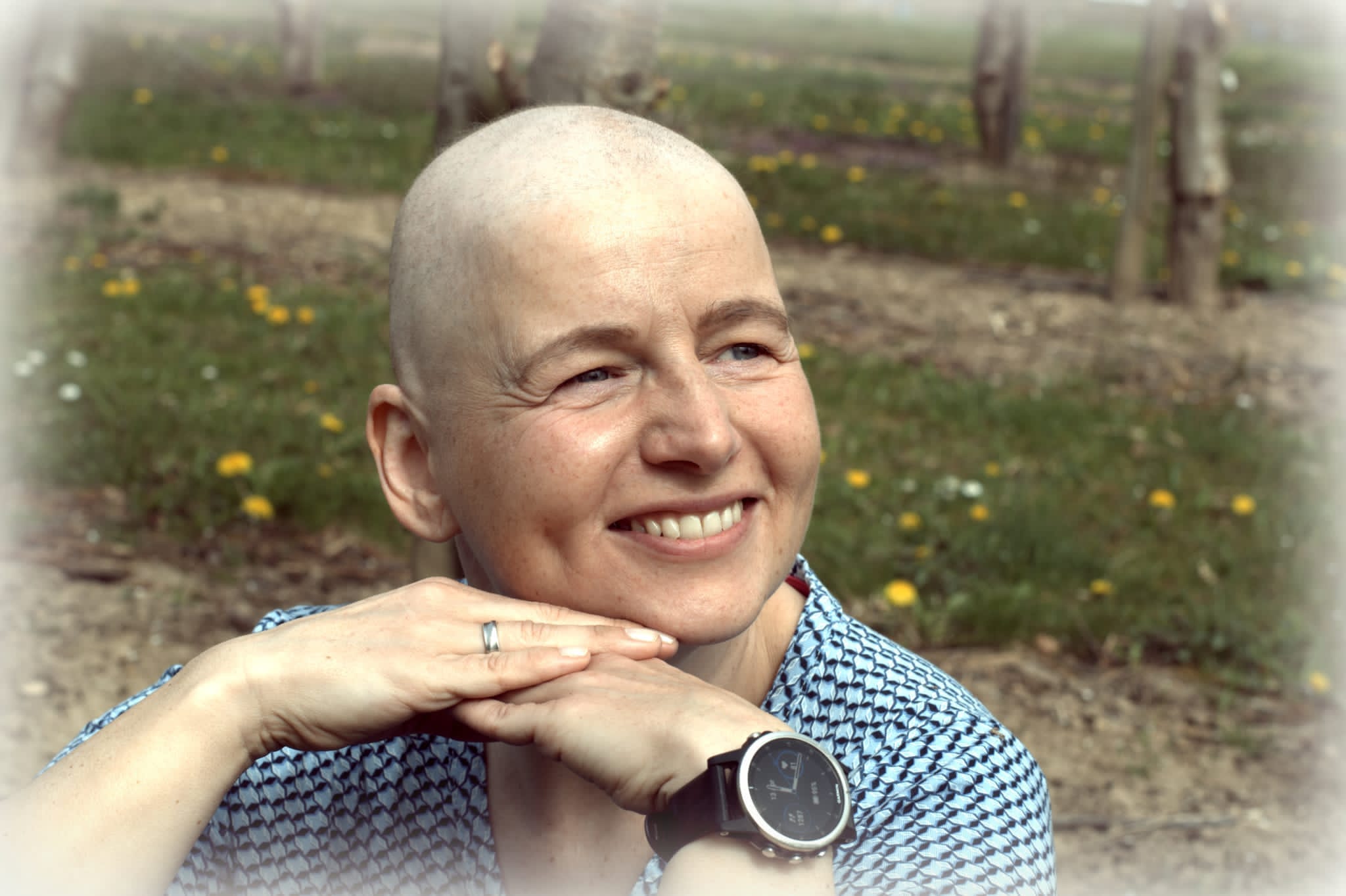 Danielle stützt das Kinn auf die Hände und lacht in die Kamera