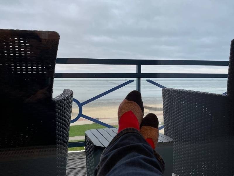 Füße mit roten Socken und Meerblick