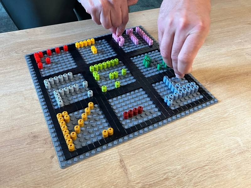 2 Hände bauen an einem Lego® Modell