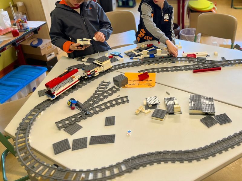 Kinder bauen Lego-Eisenbahn und Bahnhof