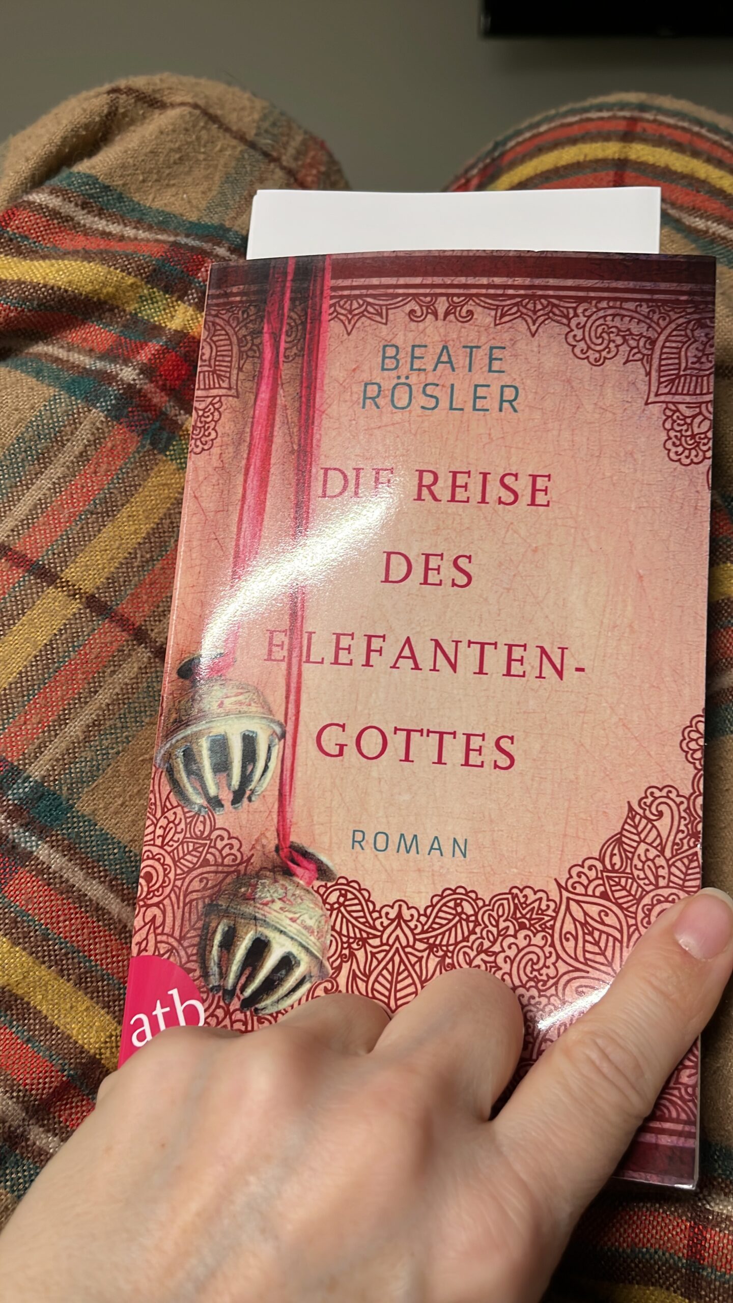Roman "Die Reise des Elefantengottes" von Beate Rösler auf einer Wolldecke