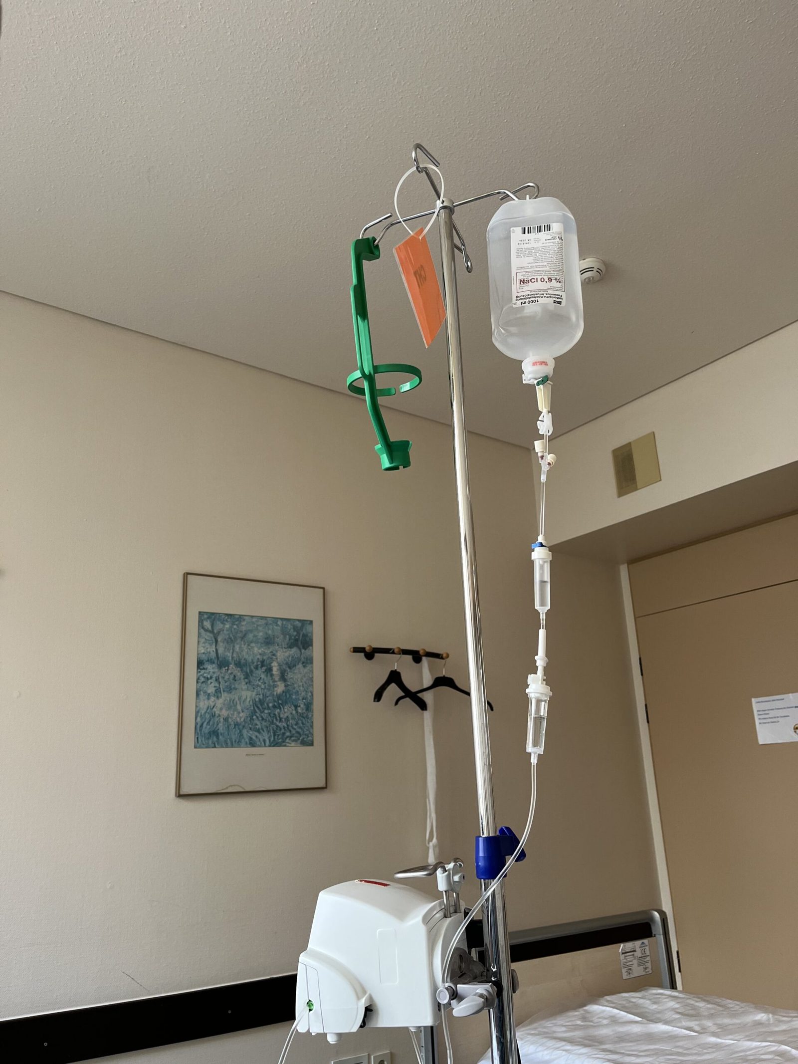 Infusionsständer mit Kochsalzlösung neben dem Krankenhausbett
