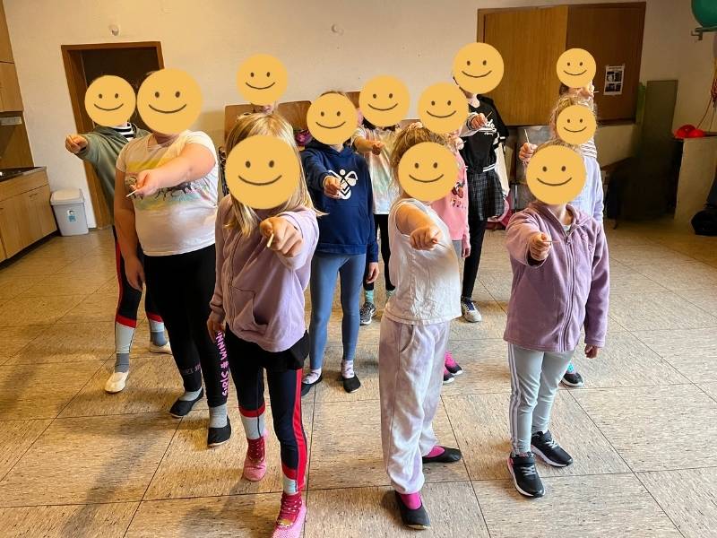 viele Kinder mit Smileys, zeigen nach vorne