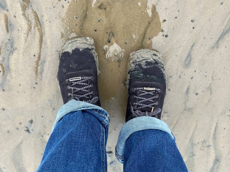 Schwarze Barfußschuhe im Watt