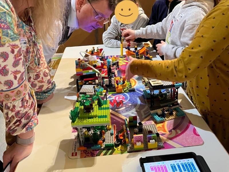 Kinder zeigen ihr Modell der First Lego League Jury
