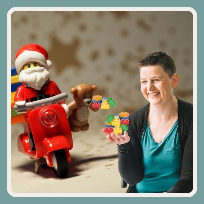 Danielle Berg mit Klemmbausteinen und Spielzeugweihnachtsmann auf einem roten Spielzeug-Moped, Sterne im Hintergrund